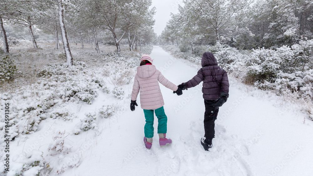 couple d'enfants marchant dans la neige fraîche couple d'enfants marchant dans la neige fraîche