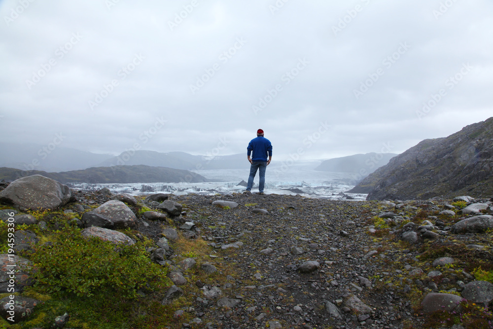 A lonely man looks and the Icelandic glacier A lonely man looks and the Icelandic glacier