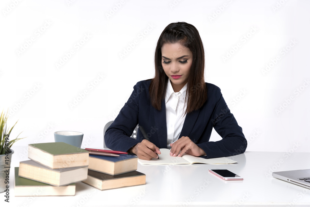 Beautiful office woman sit at table in office ,she work with laptop and use pen write report on notebook. Beautiful office woman sit at table in office ,she work with laptop and use pen write report on notebook.