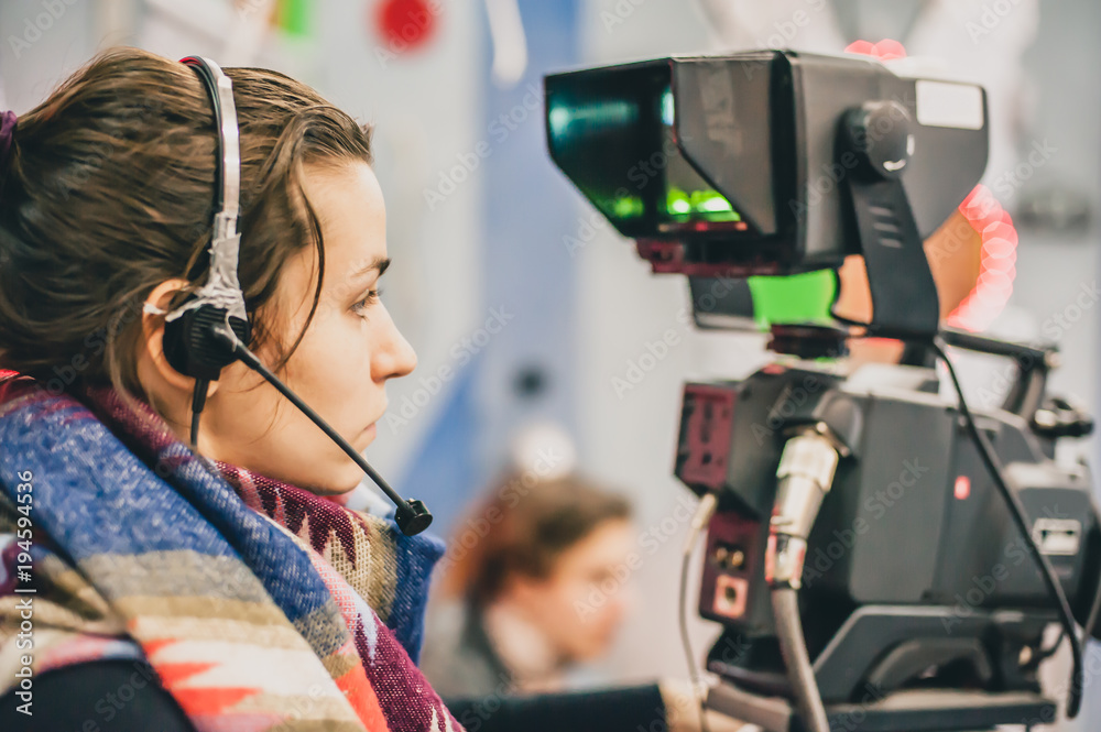 Naklejka premium Behind the scene. Female cameraman shooting film scene with camera