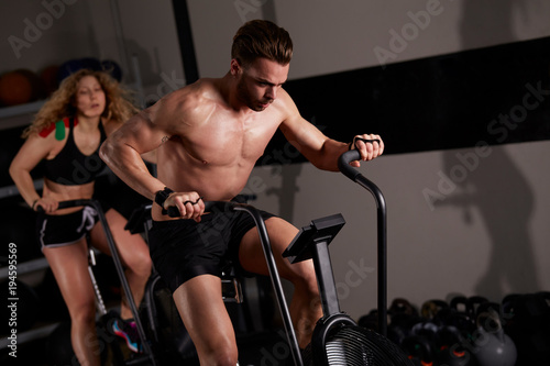 people workout at fitness club - air bike 