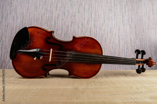The violin lies horizontally on a wooden table