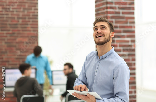 Image of a cheerful businessman working on a tablet in the offic