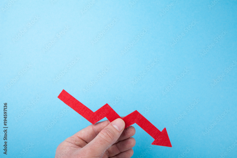 Falling red arrow down from the chart in hand on a blue background ...