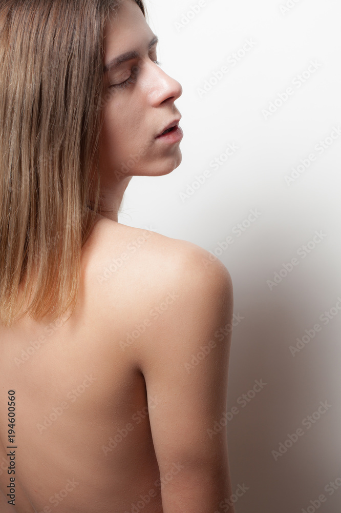 Androgynous young man on white background. Back view Androgynous young man on white background. Back view