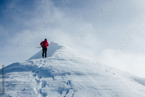 Traveler climbing Gorgany mountains in deep snow