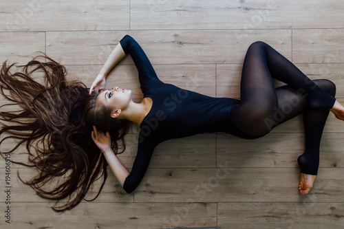 Beautiful young model ballet dancer lying inon floor. Top view. photo