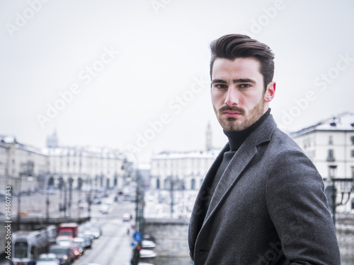 Handsome young man standing outside in winter, in snowy Turim, in Italy © starsstudio