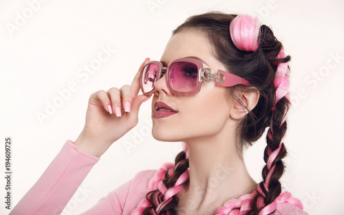 Brunette teen girl with two french braids from pink kanekalon, fashionable hairdo for youth, creative hairdresser beauty salon. Attractive female with fashion sunglasses isolated on white background.