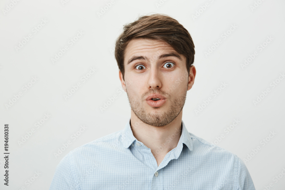 Guy is startled and stunned of seeing someone very ugly. Portrait of shocked and confused handsome man tilting head backwards, gasping from surprise while standing over gray background Guy is startled and stunned of seeing someone very ugly. Portrait of shocked and confused handsome man tilting head backwards, gasping from surprise while standing over gray background