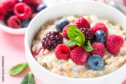 Oatmeal porrige with milk and berries close up.