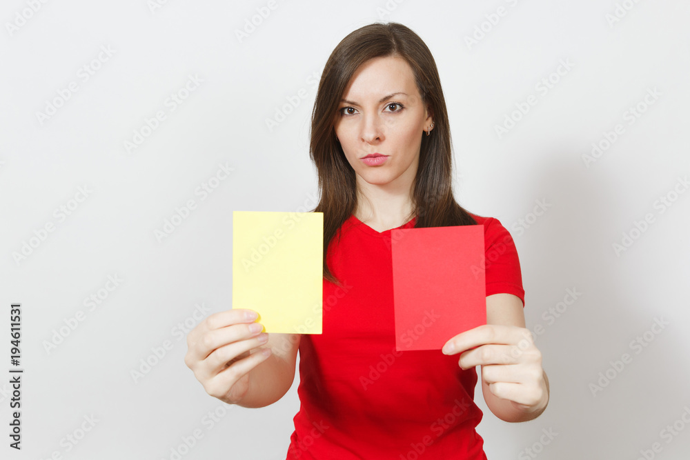 Close up serious severe young woman, football referee hold choose yellow and red soccer cards, propose player retire from field isolated on white background. Sport, play, healthy lifestyle concept. Close up serious severe young woman, football referee hold choose yellow and red soccer cards, propose player retire from field isolated on white background. Sport, play, healthy lifestyle concept.