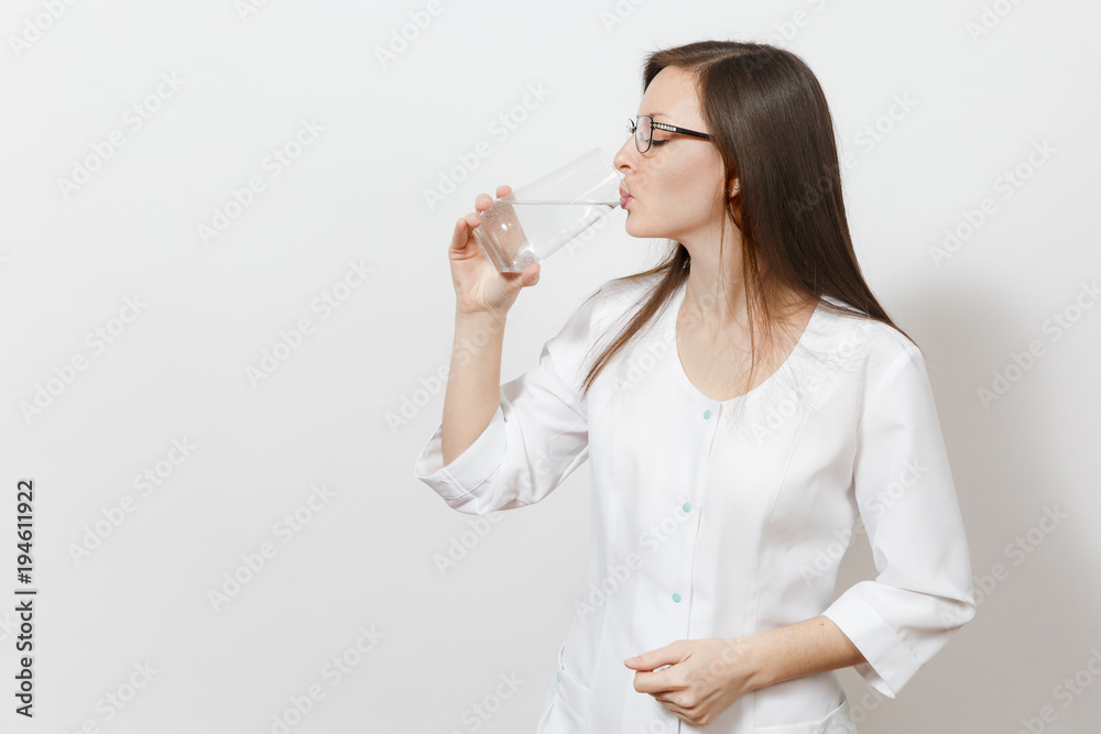 Confident beautiful doctor woman isolated on white background. Female doctor in medical gown drinking water from glass. Healthcare personnel, health, medicine concept. Copy space for advertisement. Confident beautiful doctor woman isolated on white background. Female doctor in medical gown drinking water from glass. Healthcare personnel, health, medicine concept. Copy space for advertisement.
