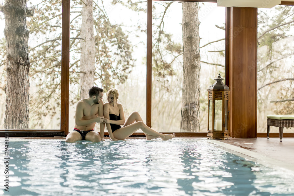 Loving couple relaxing in the spa by pool Loving couple relaxing in the spa by pool