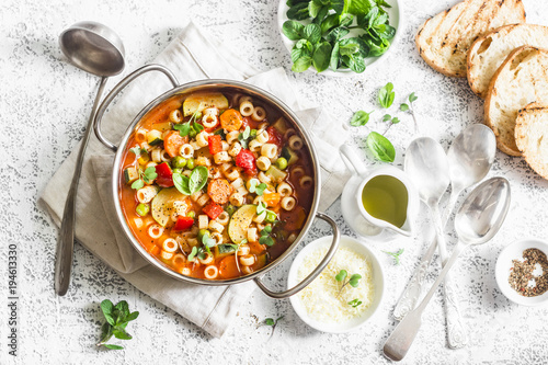 Obraz na płótnie Minestrone soup in a pan on a light table, top view