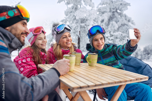 Family enjoying on tea and making selfie at ski resort © luckybusiness