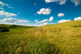 a summer landscape of rolling hills with beautiful clouds