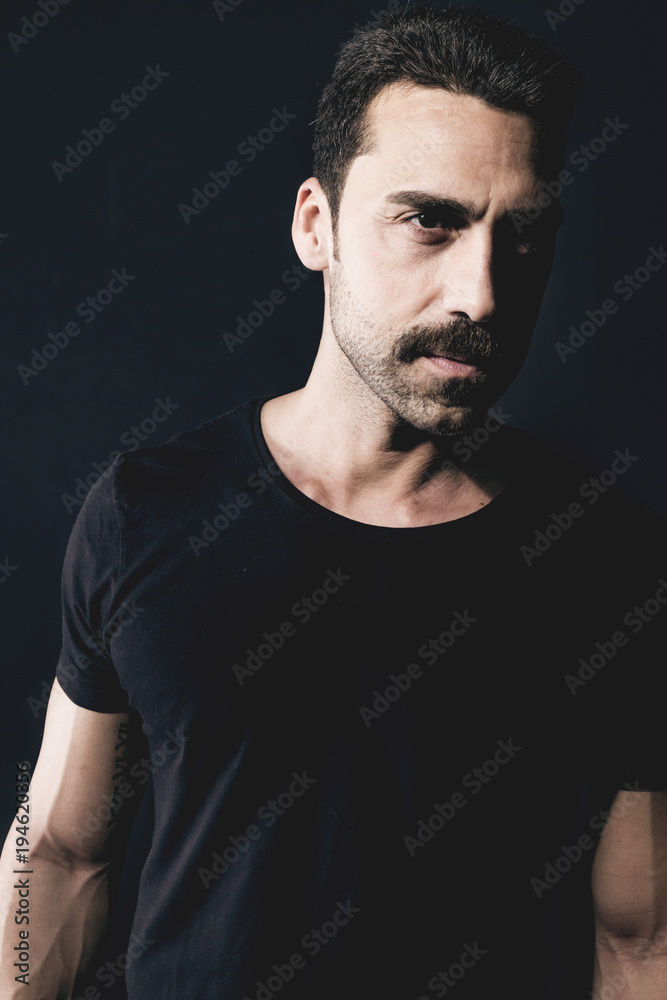 Fototapeta premium Young handsome man with beard and mustache studio portrait