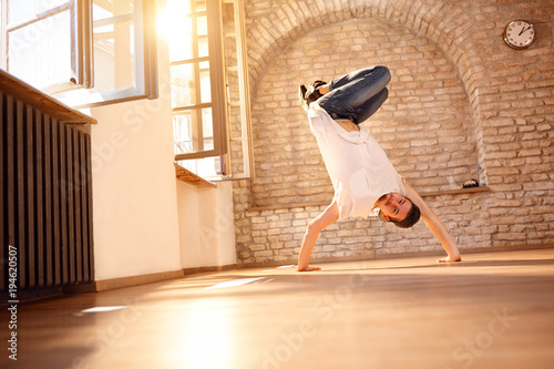 Fototapeta Naklejka Na Ścianę i Meble -  Man break-dancer doing handstand on hands
