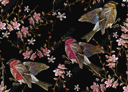 Embroidery birds and blossoming cherry seamless pattern. Classical embroidery bullfinch and titmouse on branch blossoming sakura. Spring fashion art, template for design of clothes, t-shirt design