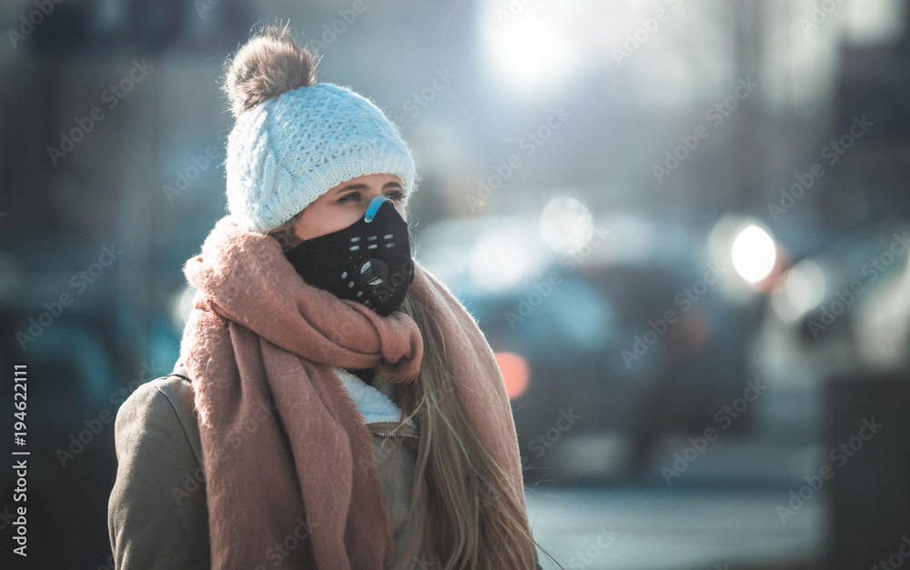Plakat Młoda kobieta jest ubranym maskę ochronną w ulicie miasta, smogu i zanieczyszczeniu powietrza