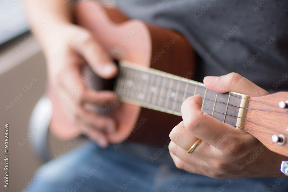 Man playing Ukelele with selective focus