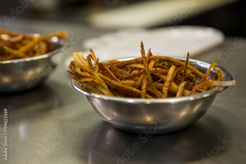 Shoestring french fries in a metal bowl
