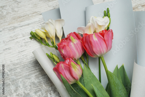 Beautiful bouquet of pink tulips and Freisia Flowers on wooden background. Spring bouquet for Gift with Copy Space. photo