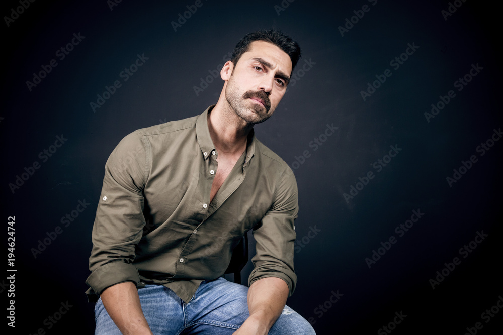 Fototapeta premium Young handsome man with beard and mustache studio portrait
