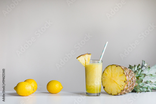 pineapple juice with pineapple and lemons in backround