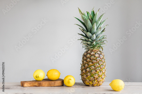 Pienaple and lemons on white background