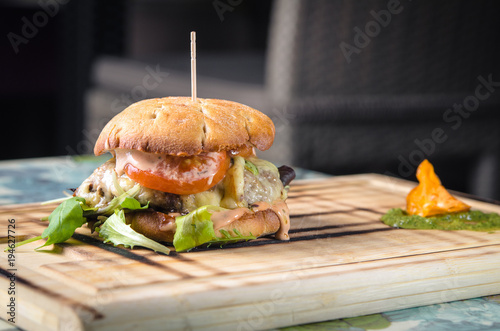 Cheesy hamburger on cutting board