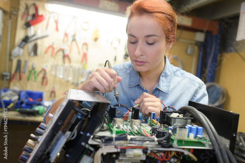 young woman technician repair electronics device toned image