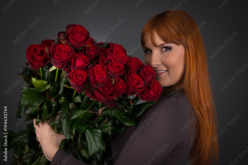 Young woman with ginger hair on international womens day with a lot of flowers Young woman with ginger hair on international womens day with a lot of flowers