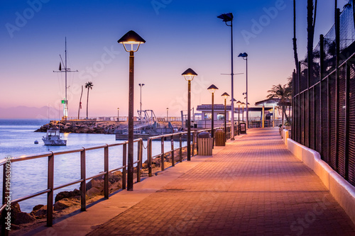 Brick walkway to boat dock in early sunrise light  streelights on  shadows  quiet  calm peaceful  Avalon  Santa Catalina Island  California