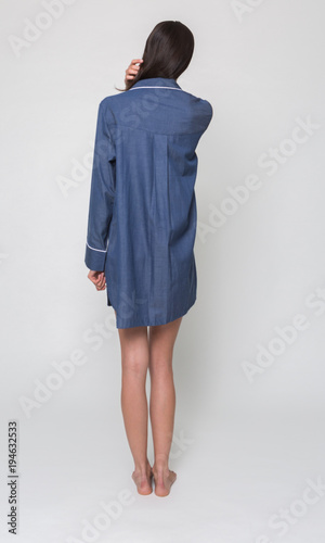 manchester, England, 05/07/2016, A beautiful tall brunette girl in a blue short night pyjama dress, night wear, evening sleep wear. isolated on a white backdrop.