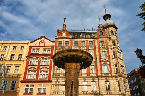 Fountain and facades of historic tenements on the market square in Swidnica in Poland.