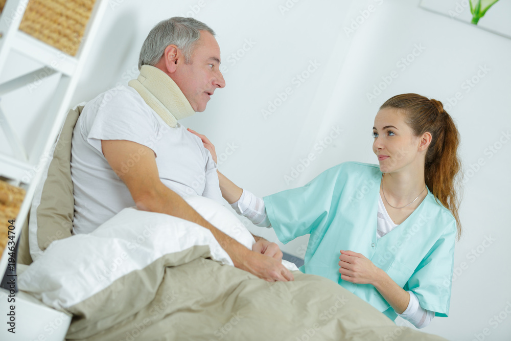 Obraz premium nurse taking care of injured man in bed at home
