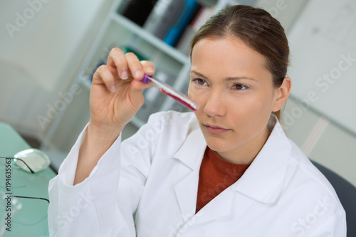 Fototapeta Naklejka Na Ścianę i Meble -  Woman examining test tube