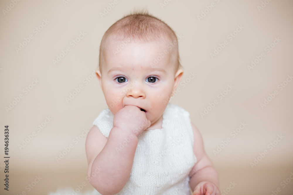 Close portrait of cute little baby boy, isolated on beige background, baby making different facial expressions Close portrait of cute little baby boy, isolated on beige background, baby making different facial expressions