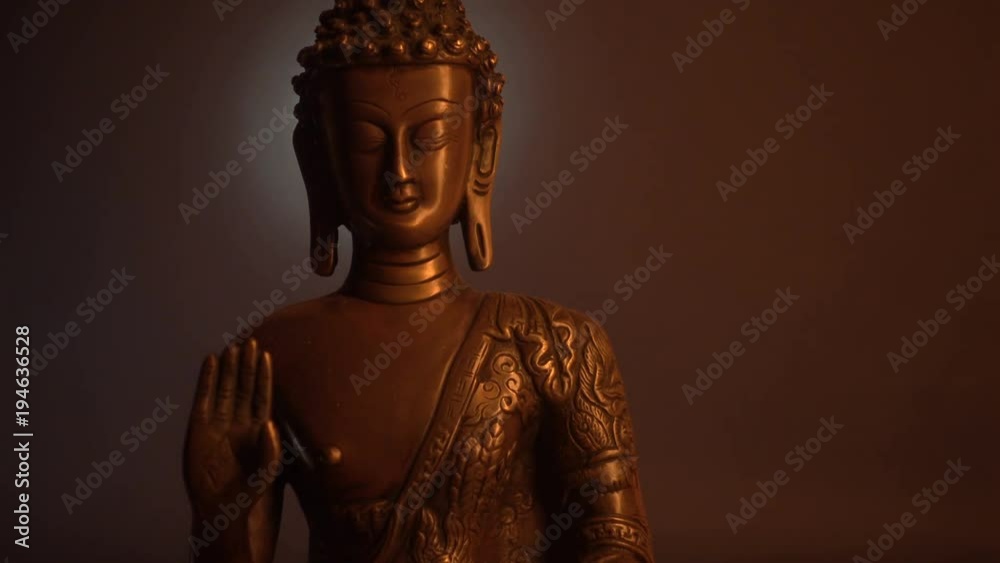 Statuette of Buddha on the black background. Moving of the light. Statuette of Buddha on the black background. Moving of the light.