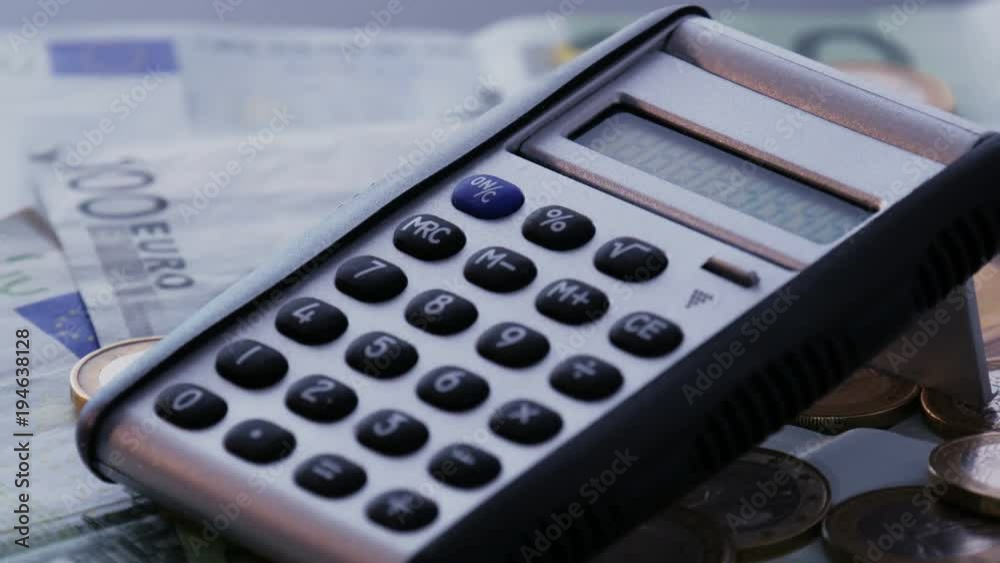 Calculator on euro coins and bills. Loopable rotation shot. Calculator on euro coins and bills. Loopable rotation shot.