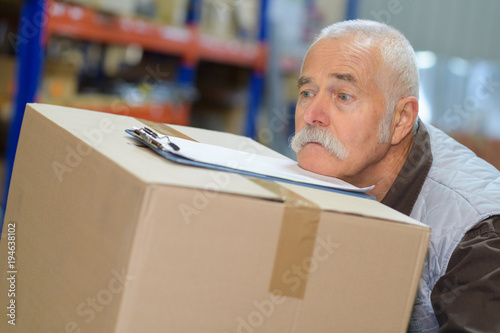 senior man struggling with a delivery box