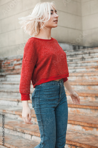 Beautiful blonde young woman is walking around the city