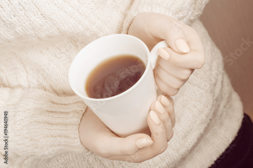 Woman's hands holding hot cup of coffee