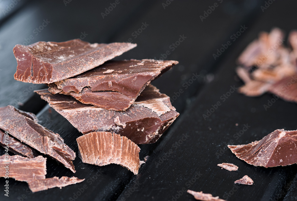 Delicious Chocolate pieces on a dark wooden moody background, closeup macro, with lots of texture Delicious Chocolate pieces on a dark wooden moody background, closeup macro, with lots of texture