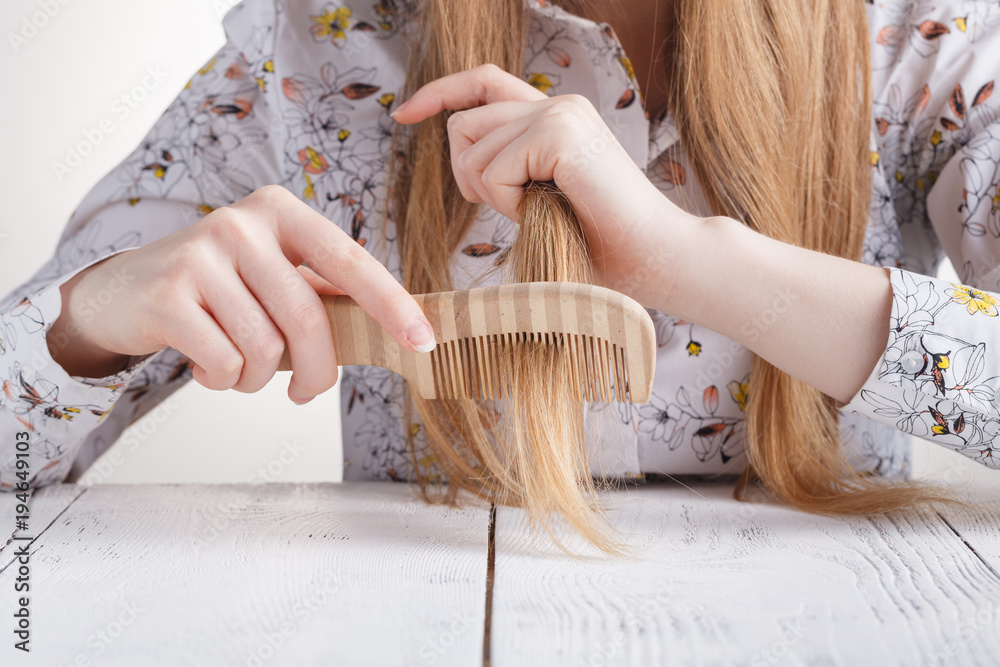 Obraz premium Woman with a comb in her hands problem hair