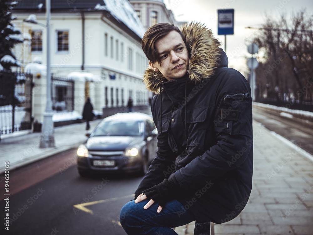 Fototapeta premium young fashion traveller in the european street sitting near the road