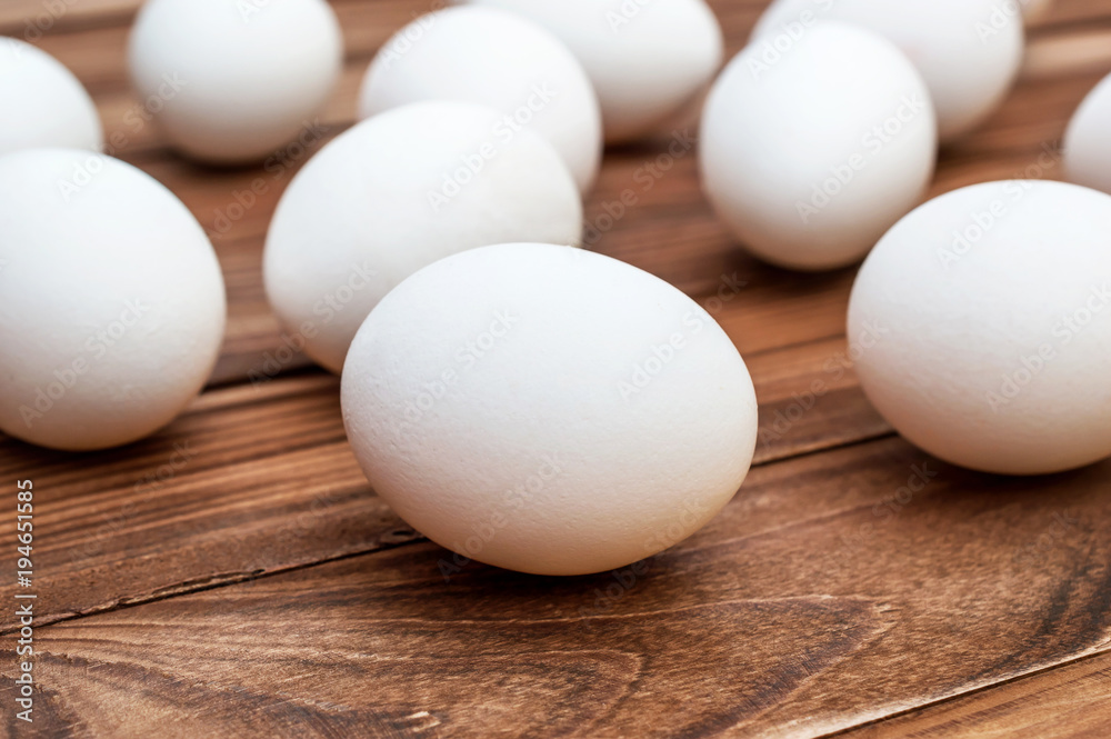 White eggs on the brown wooden table. White eggs on the brown wooden table.