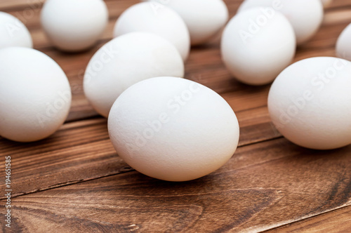 White eggs on the brown wooden table.